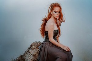 Redheaded woman in a strapless dress with Viking braids